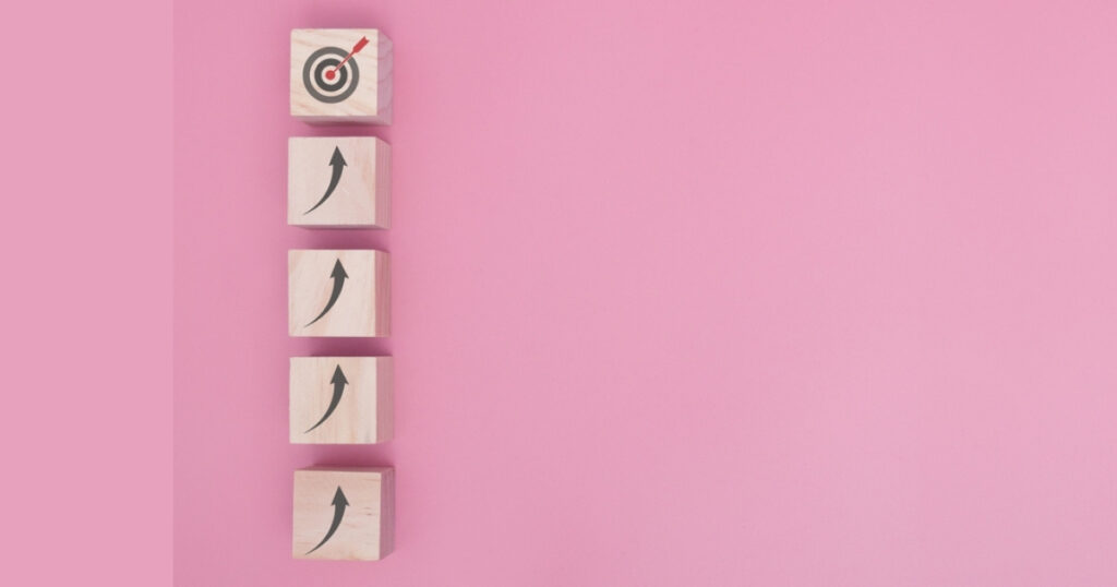 Wood blocks with arrows aiming at target.