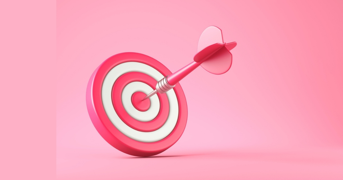 Pink dart hitting bullseye on target