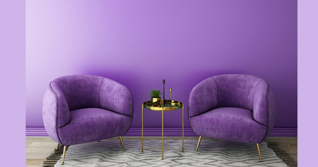 Two purple chairs and table in a purple room.