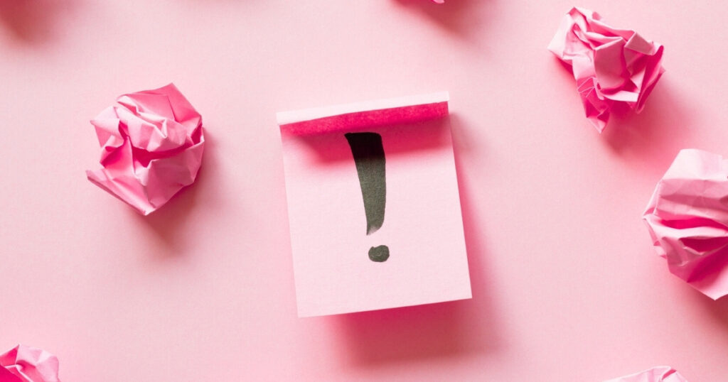 Pink paper with exclamation mark and crumpled balls
