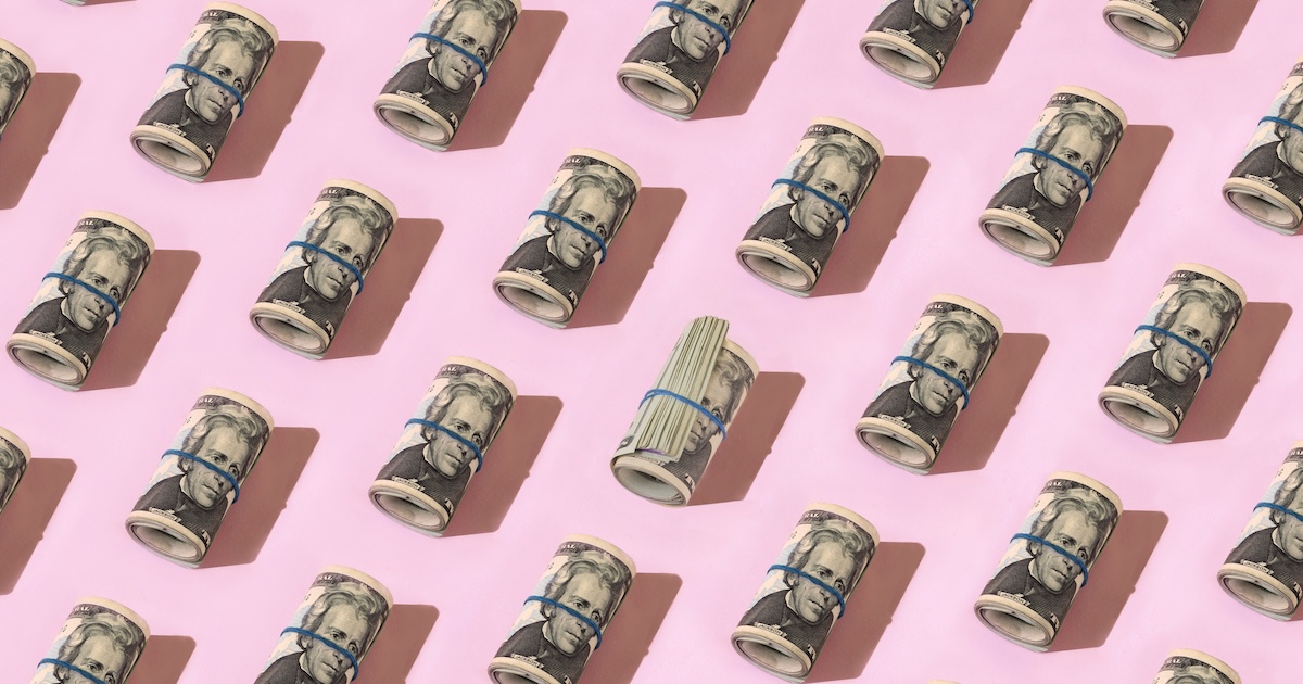 Pattern of rolled money on pink background.