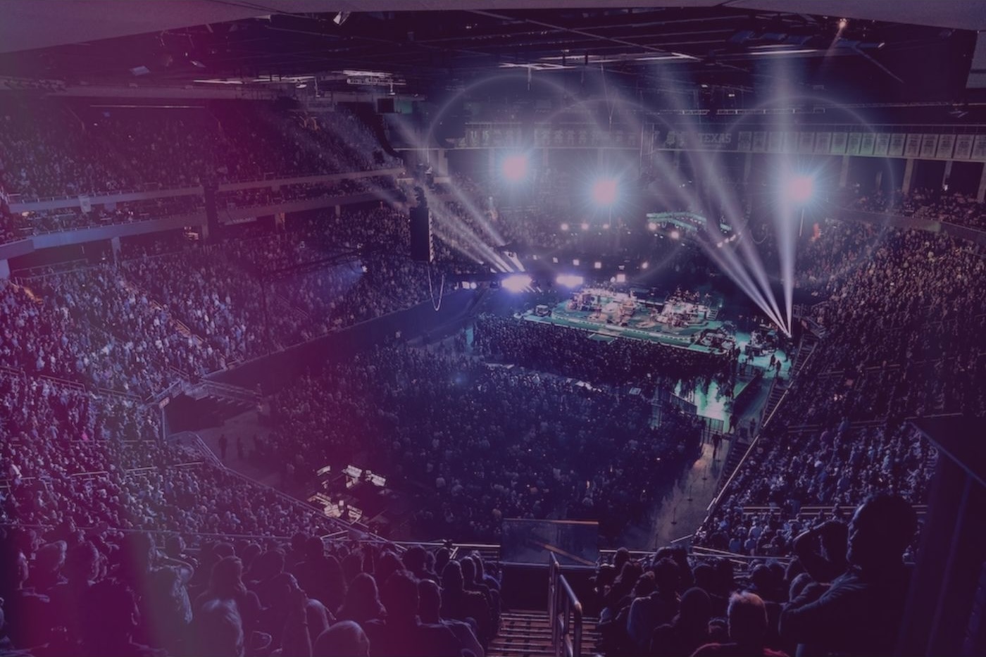 Crowded arena during a concert with bright lights.