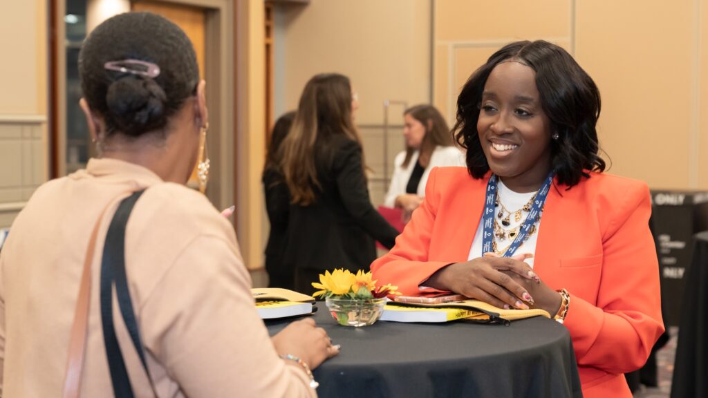 Two women chatting at a business networking event.